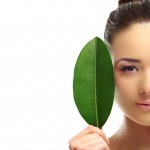 Portrait of beautiful woman with green leaf which isolated on white background, close up