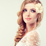 Beautiful model in lace dress with a pigtail , flower barrette